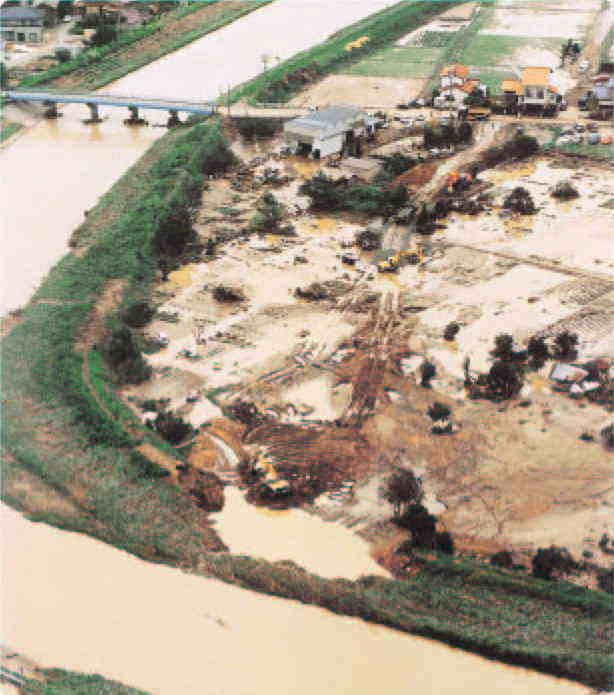 加賀市内の動橋川において、大雨による増水で右岸堤防が決壊した状況を撮影した航空写真