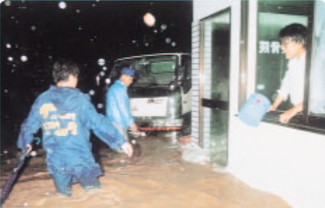 金沢市内の碇川が越水し、膝上まで濁流が押し寄せている写真