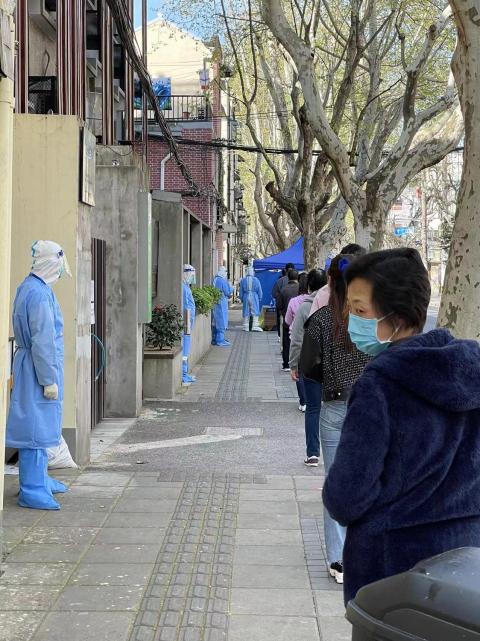 ロックダウン中の上海市内でPCR検査を受けるため列をつくる住民